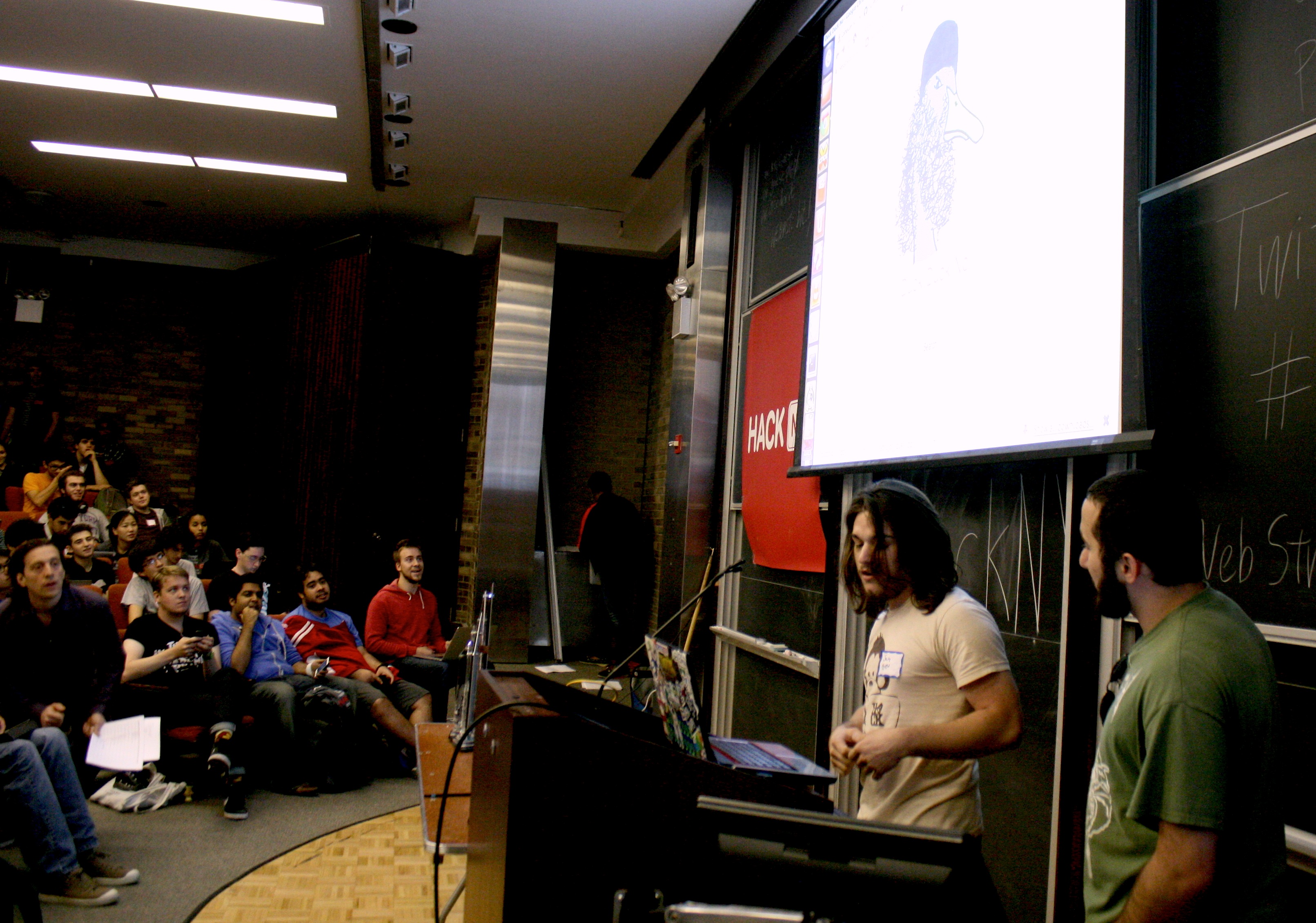 Student presenters demoing their project to an audience at the fall 2013 hackNY Student Hackathon at NYU.